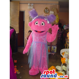 Tall pink friendly looking monster mascot with violet pig tails