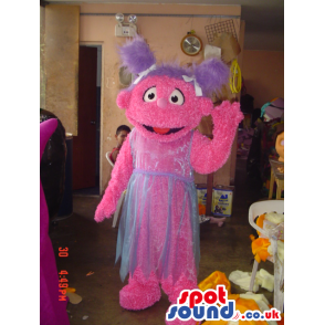 Tall pink friendly looking monster mascot with violet pig tails