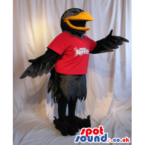 Black Bird Plush Mascot Wearing A Red T-Shirt With A Logo. -