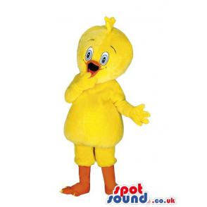 Yellow chicken mascot in cute smile and with an innocent look -