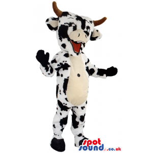 White standing cow mascot with black patches and brown horns