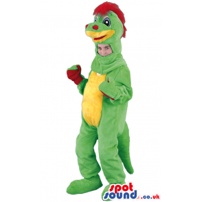 Standing green dinosaur mascot with red hair, palms and