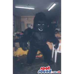 Giant, fluffy gorilla mascot with brown nails and white teeth -