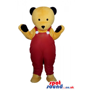 Bear mascot looking to the front with red gardener trousers -