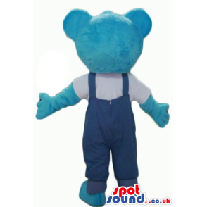 Smiling light blue teddy bear in blue gardener trousers and