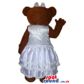 Chocolate brown teddy bear in silky white wedding dress -