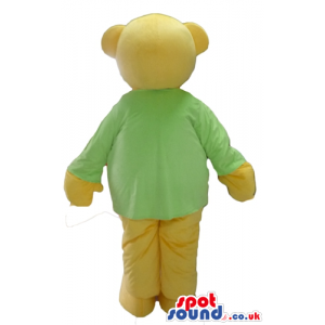 Smiling beige bear wearing a green sweater and beige trousers -