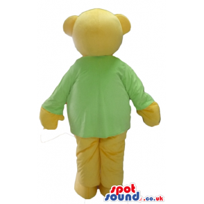 Smiling beige bear wearing a green sweater and beige trousers -