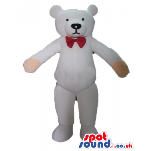Serious white teddy bear with pink hands wearing a small red