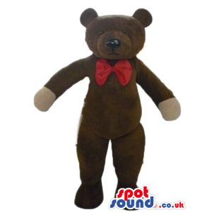 Serious brown teddy bear with beige hands and red bow tie -