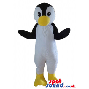 Black and white penguin with big yellow beak and yellow feet -