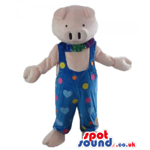 Pink pig wearing a blue gardener trousers with pink, yellow