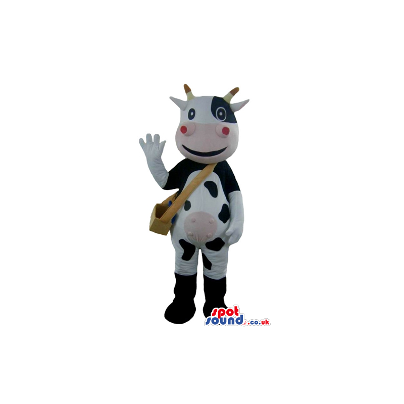 Smiling black and white cow with yellow horns, a pink mouth and