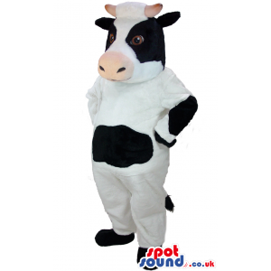 Standing white cow mascot with black patches and cream snout