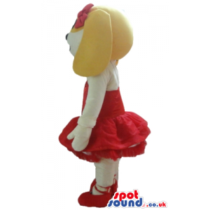 Female beige and white dog wearing a red ballet dress and red