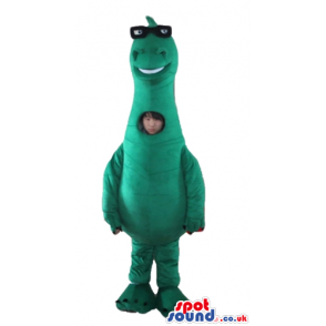 Green dino with black glasses and a picture on the chest -