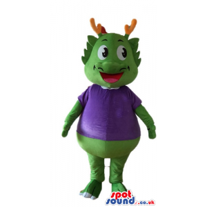 Green smiling monster with orange horns wearing a violet