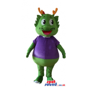 Green smiling monster with orange horns wearing a violet