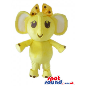 Yellow elephant with white ears and a yellow and black ribbon -